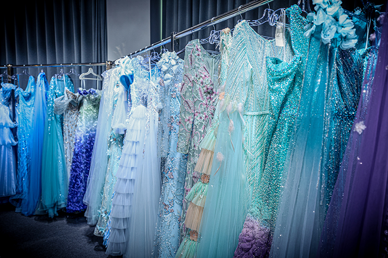 Filas de vestidos terminados colgados en rails